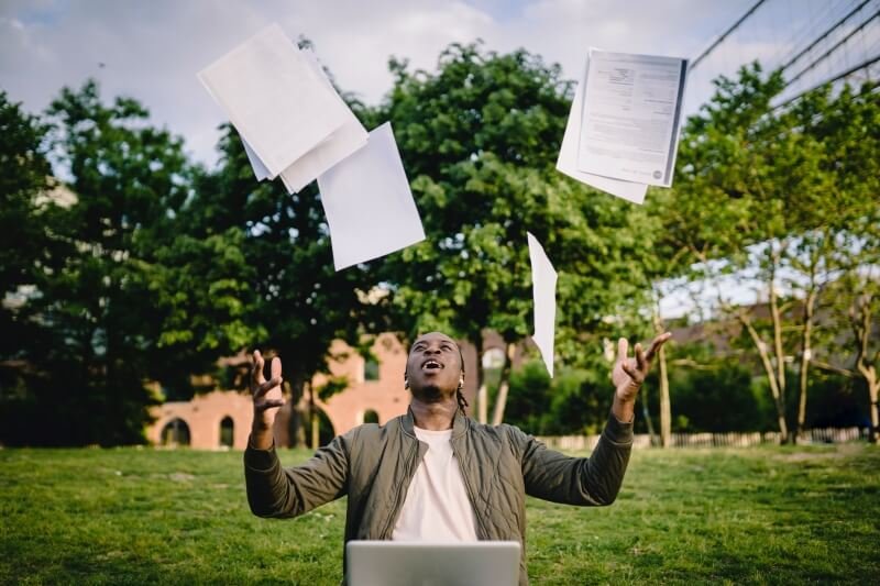 Happy person throwing paper in the air